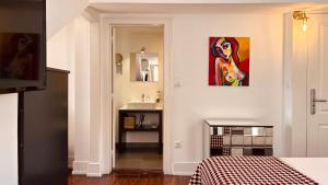 a bedroom with a painting of a woman on the wall at Casa do Jasmim by Shiadu in Lisbon