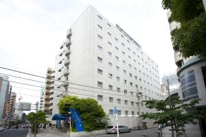 um edifício branco alto numa rua da cidade em Pearl Hotel Kayabacho em Tóquio