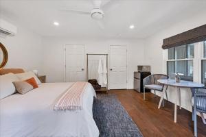 ein Schlafzimmer mit einem weißen Bett, einem Tisch und einem Tisch in der Unterkunft Relaxing Alpaca Ranch Mins from Downtown Wimberley in Wimberley