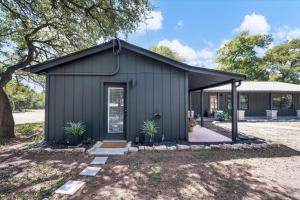 a black shed with plants in a yard at Relaxing Alpaca Ranch Mins from Downtown Wimberley in Wimberley