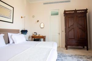 a bedroom with a bed and a wooden cabinet at House 1923 Boutique Hotel in Pano Lefkara