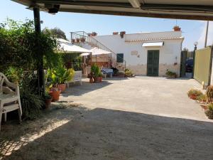 a patio with potted plants and a building at Country house pool and sea in Agnone Bagni