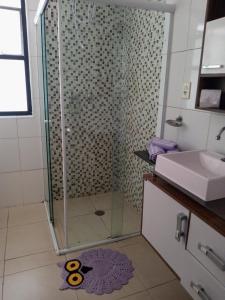 a bathroom with a glass shower with a sink at Palladium Apart Service in São Vicente