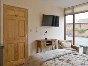 una camera da letto con un letto e una televisione a parete di Skylark - Uk30746 a Acton Trussell