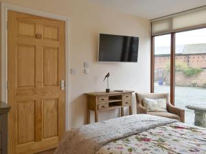 a bedroom with a bed and a television on the wall at Skylark - Uk30746 in Acton Trussell