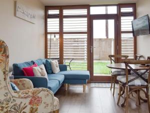 a living room with a blue couch and chairs at Skylark - Uk30746 in Acton Trussell
