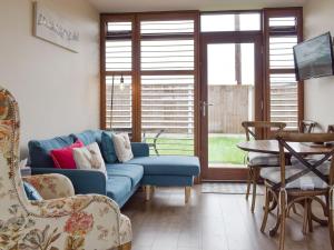 uma sala de estar com um sofá azul e cadeiras em Skylark - Uk30746 em Acton Trussell