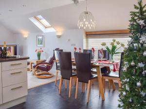 a dining room with a christmas tree and a table and chairs at The Plucking Barn in Llanwenog