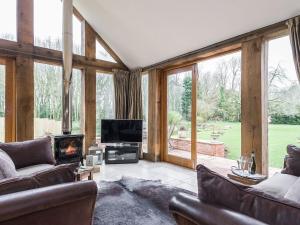 a living room with couches and a fireplace and windows at Lily Pad Lodge in Donington on Bain