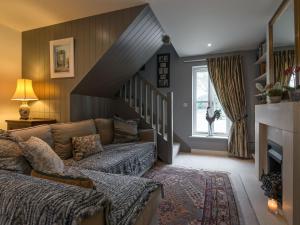 a living room with a couch and a staircase at Lily Pad Lodge in Donington on Bain