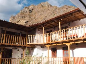 a building with wooden balconies and a mountain in the background at Luisa in Ollantaytambo