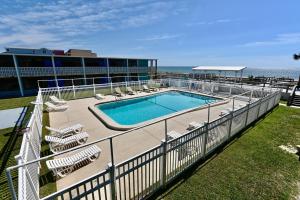 a swimming pool with lounge chairs next to a building at Buccaneer Inn in St. George Island