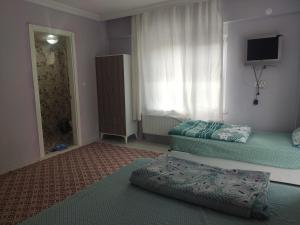 a living room with two beds and a window at Kaplan Apart - Pansiyon in Yeşilova