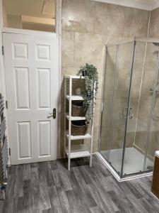 een badkamer met een douche en een glazen deur bij Modern 4 Bedroom House 10 mins from East Croydon with Garden and Free parking in South Norwood