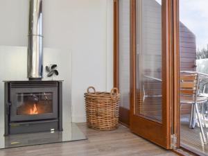 a fireplace in a living room next to a patio at Waterside Lodge Sixteen - Uk13038 in Southowram