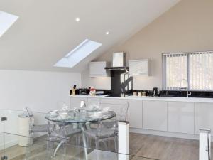 uma cozinha branca com uma mesa de vidro e cadeiras em Waterside Lodge Sixteen - Uk13038 em Southowram