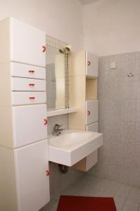 a white bathroom with a sink and a mirror at Apartment Zrnovska Banja 3154a in Korčula