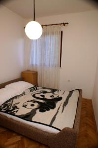 a bedroom with a bed with a black and white blanket at Apartments by the sea Zrnovska Banja, Korcula - 3154 in Korčula