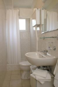 a white bathroom with a sink and a toilet at Rooms by the sea Zuljana, Peljesac - 3163 in Žuljana