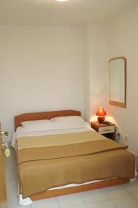 a bedroom with a bed with a mirror and a lamp at Rooms by the sea Zuljana, Peljesac - 3163 in Žuljana