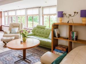 a living room with a green couch and a table at Middle Lodge in Mintlaw