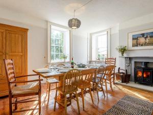 een eetkamer met een tafel en stoelen en een open haard bij Colveston Manor in Cranwich