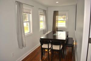 a dining room with a table and chairs and two windows at Stylish 4-Bedroom Full House. Plenty of Parking! in Catonsville