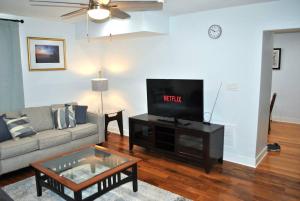 a living room with a couch and a flat screen tv at Stylish 4-Bedroom Full House. Plenty of Parking! in Catonsville