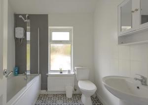 a white bathroom with a toilet and a sink at Birmingham Contractor House sleeps 8 Private Garden near M6 Motorway Business Wi-FI in Birmingham +36 photos