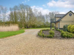 a house with a gravel driveway in front of a house at Hill Farm Cottage in Stretham