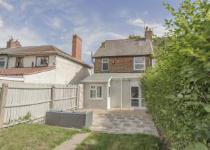 a white house with a fence and a yard at Birmingham Contractor House sleeps 8 Private Garden near M6 Motorway Business Wi-FI in Birmingham