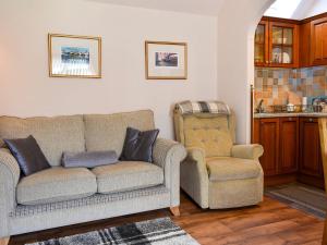 a living room with a couch and two chairs at Heron Cottage in Lossiemouth