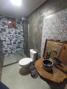 a bathroom with a toilet and a sink at Canto Ybykuara - Natural Guest House in Ibicoara
