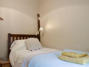 a bedroom with a bed with two towels on it at Cenwulf Cottage in Winchcombe