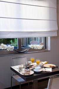 a dining room table with a window with a white blind at Hotel Carla in Levanto