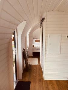 a white room with a bed and an arched hallway at Tirolian Lodge South in Bundorf