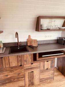 a kitchen with wooden cabinets and a sink at Tirolian Lodge South in Bundorf