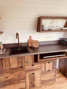 a kitchen with wooden cabinets and a sink at Tirolian Lodge East in Bundorf