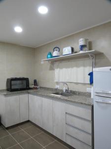 a kitchen with a sink and a microwave at Cabaña La Verdicchio Urbanización Cristobal Lote 2 in Valle Grande