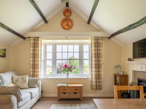 a living room with a couch and a window at Garden Cottage in Morland