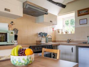 a kitchen with a bowl of fruit on a table at Garden Cottage in Morland