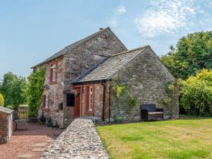 an old stone house with a red door at Garden Cottage in Morland