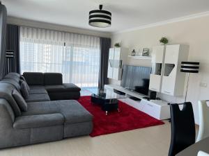 a living room with a gray couch and a red rug at Rocha Prime - Standing apartment T3 in Portimão