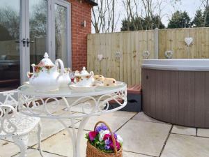 a white table with tea sets on a patio at Hares Home - Uk10757 in Barney