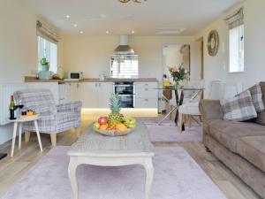 a living room with a table with a bowl of fruit on it at Hares Home - Uk10757 in Barney