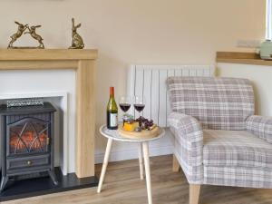 a living room with a chair and a table with wine glasses at Hares Home - Uk10757 in Barney