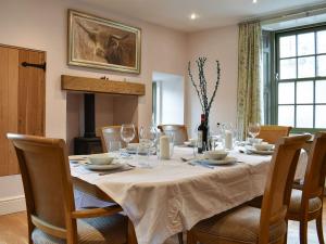 a dining room table with a white table cloth and chairs at Ellerton House in Richmond
