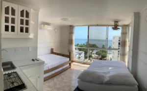 a bedroom with a bed and a balcony with a view at Luna Azul Rodadero apartaestudios in Santa Marta