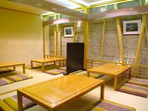 a room with wooden tables and a tv in it at Hotel Higashinihon Utsunomiya in Utsunomiya