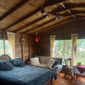 um quarto com uma cama e um sofá num quarto em Cabaña Sueños Dorados em Guatavita